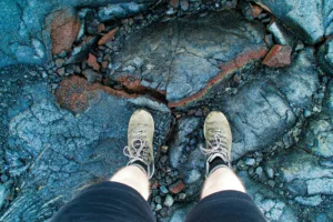 Feet standing on basalt lava rock in Hawaii Volcanoes National Park
