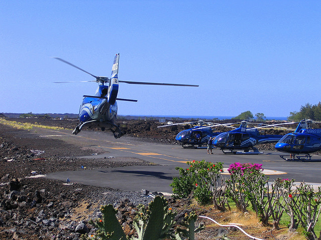 Blue helicopters for Hawaii volcano tours on gravel runway